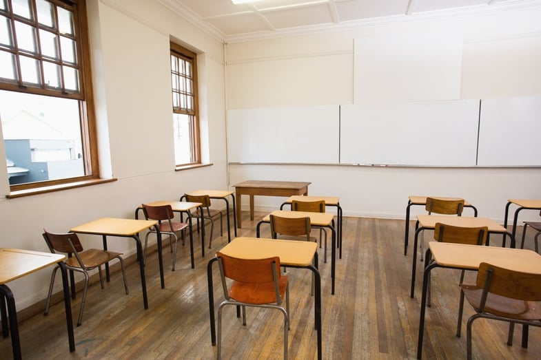 Empty classroom with empty chairs and desks.jpeg