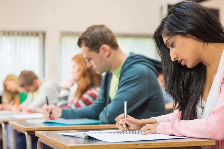 Side view of a group of young students writing notes in the classroom.jpeg